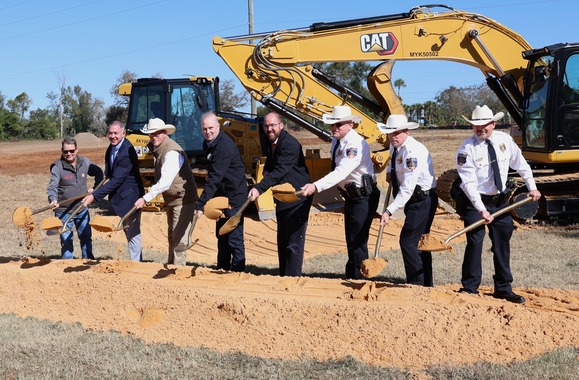 Officials posing with shovels at a groundbreaking ceremony