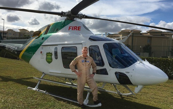 A firefighter standing in front of a Florida Forest Service helicopter