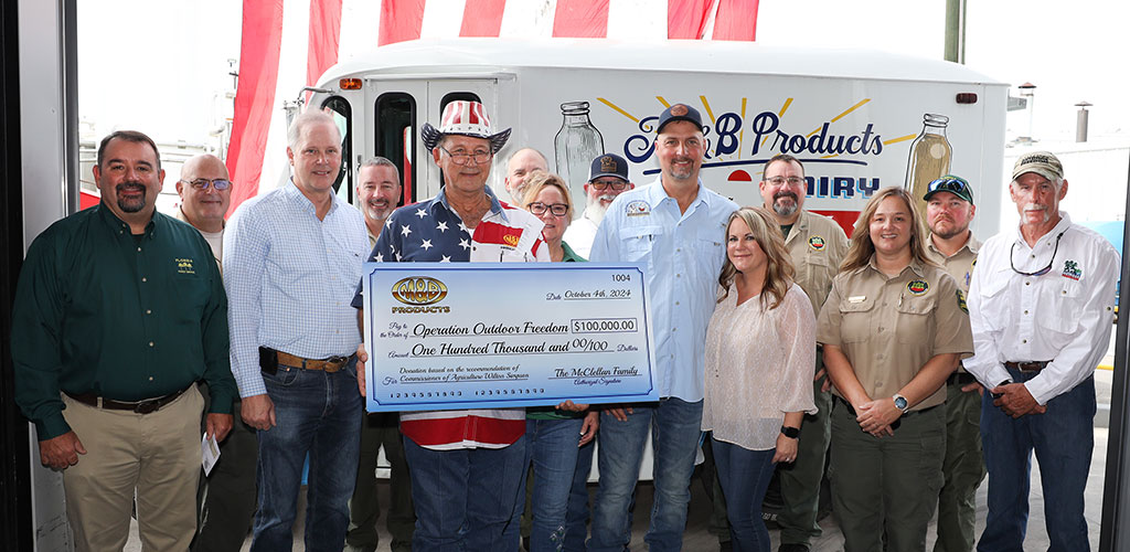 Commissioner Simpson with Dale McClellan, who is holding a giant check and surrounded by his family
