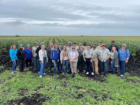 A group of educators smiling in a farm field