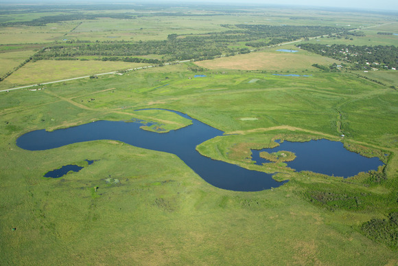 An aerial view of a dairy farm with ponds and green pastures