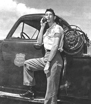 A forest service employee talking on a radio in his truck